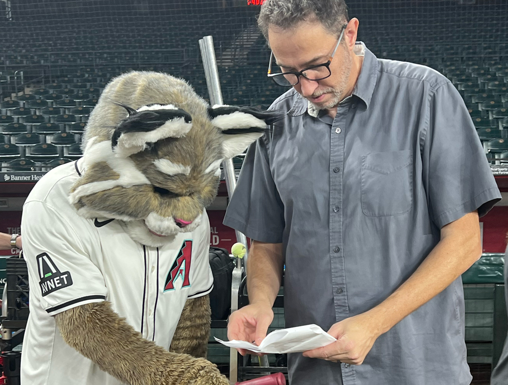 Christophe Tinard directing a baseball mascot performance from a production monitor